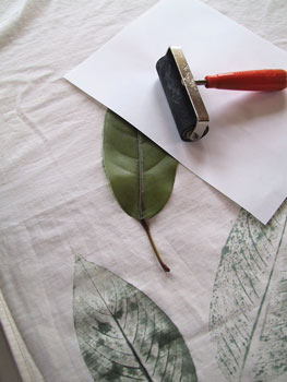Press the leaf into the fabric and cover with paper. Smooth with a roller or your hand.